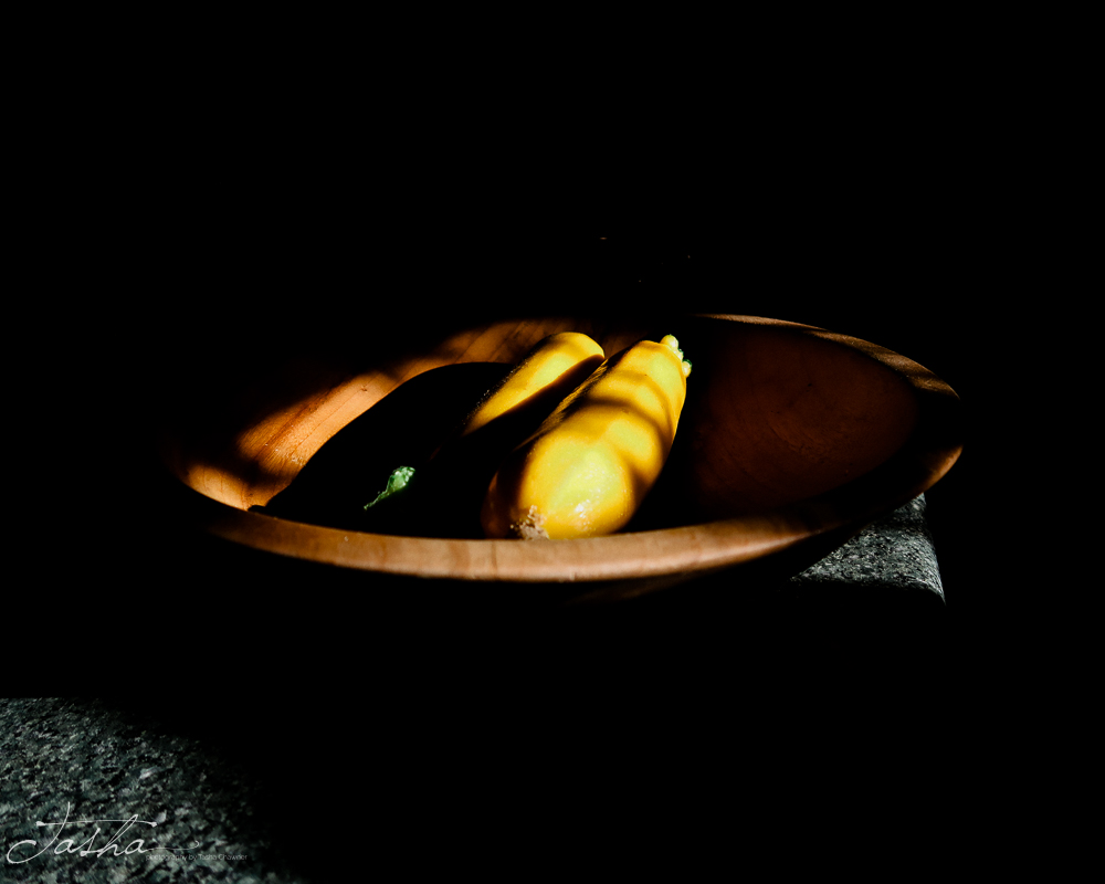 late afternoon light on zucchinis in a bowl